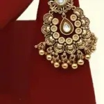 Antique gold brass bridal necklace set with Kundan stones, matching earrings, and maangtika on red display, Ishwar Arts and Crafts