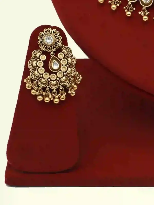 Antique gold brass bridal necklace set with Kundan stones, matching earrings, and maangtika on red display, Ishwar Arts and Crafts